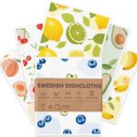 Six Aitoper Swedish dishcloths with various fruit patterns, neatly stacked or fanned out on a kitchen counter.