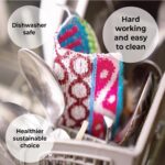 Four assorted color Skoy Scrubs, round with various patterns, arranged on a clean kitchen counter next to a sink.